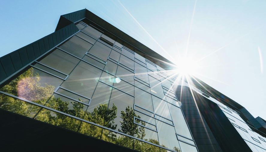 Trees reflecting in the mirrored surface of a large office block