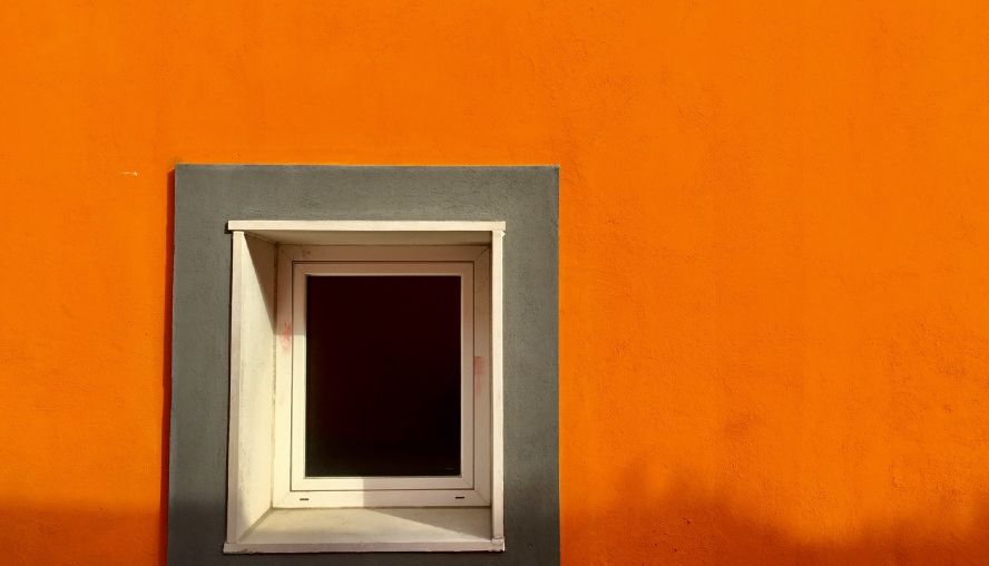 A window on an orange building wall.