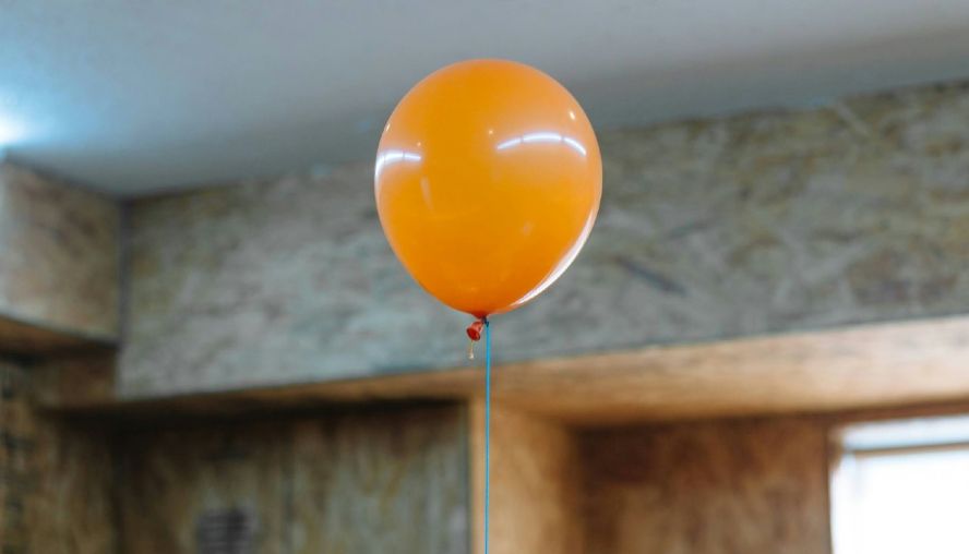 An ornage baloon floating upwards